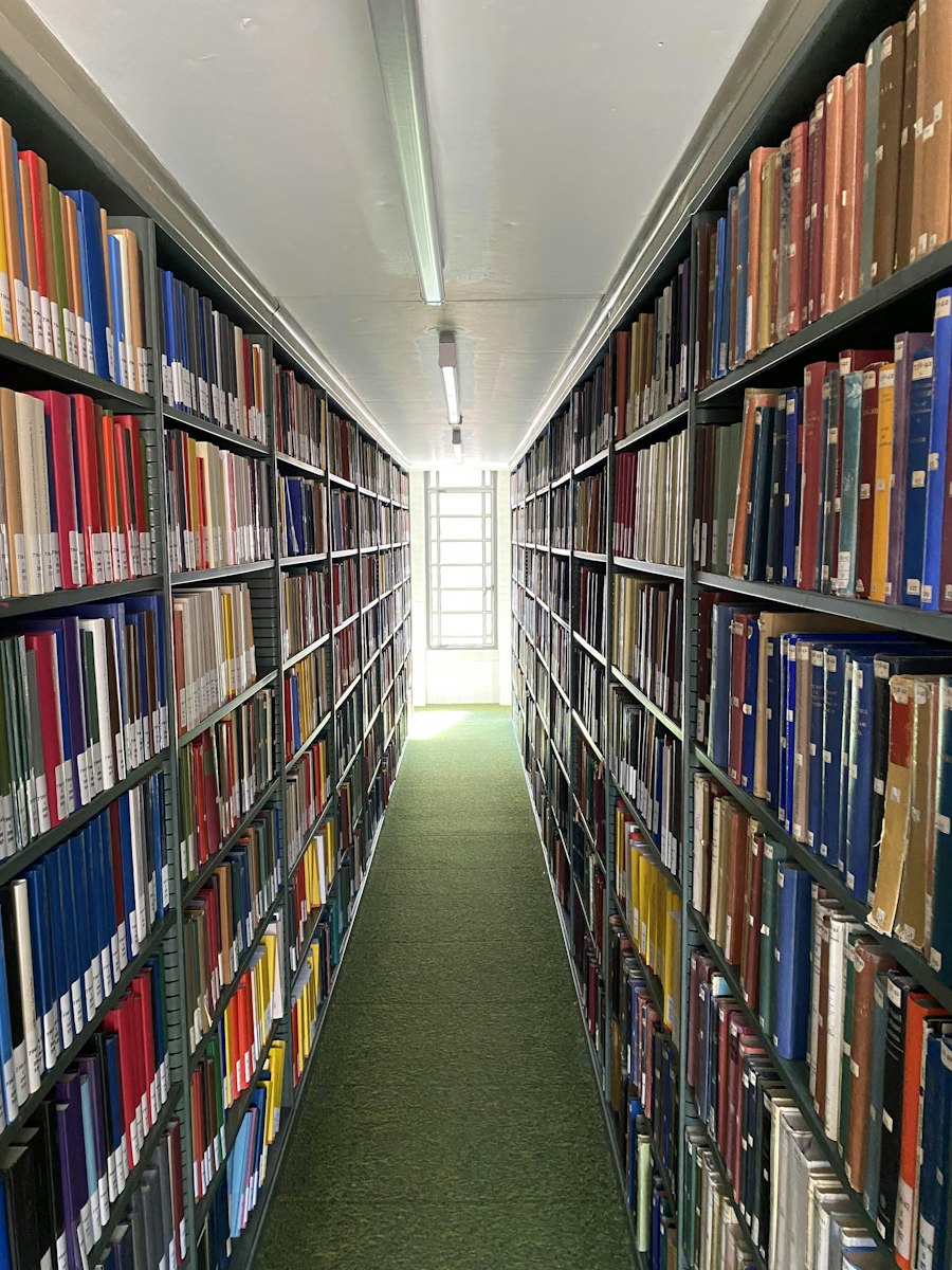 Pasillo de una biblioteca con estanterías de libros.